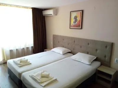 two beds in a hotel room with towels on them at Panorama Hotel in Sandanski