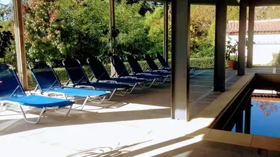 a row of blue chairs sitting next to a swimming pool at Panorama Hotel in Sandanski