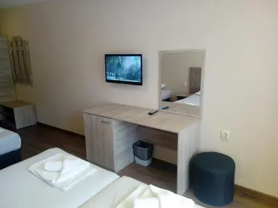 a room with a desk with a mirror and a bed at Panorama Hotel in Sandanski