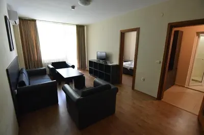 a living room with chairs and a table and a bed at Panorama Hotel in Sandanski