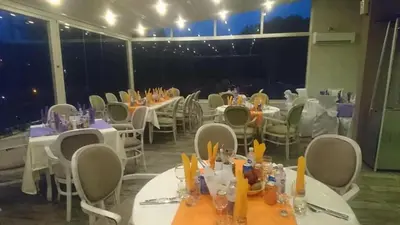 a dining room with tables and chairs and lights at Panorama Hotel in Sandanski