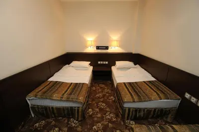 two beds in a small room with two lamps at Hotel & Restaurant The House in Sofia