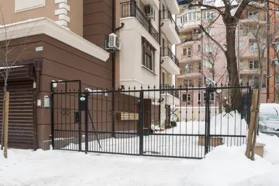 a black gate in the snow in front of a building at M&M Modern & Multifunctional One Bedroom Apartment by Flat Mаnager in Sofia