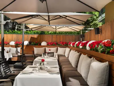 a restaurant with white tables and chairs and red flowers at Crystal Palace Boutique Hotel in Sofia