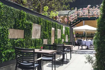a restaurant with a green wall with tables and chairs at Crystal Palace Boutique Hotel in Sofia