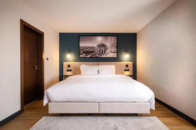 a bedroom with a large white bed with a black wall at Metropolitan Hotel Sofia, a member of Radisson Individuals in Sofia