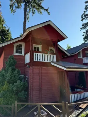 a red house with a porch and a balcony at Alpin Borovets, Алпин Боровец in Borovets