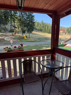 a balcony with a table and chairs and a view of a field at Alpin Borovets, Алпин Боровец in Borovets