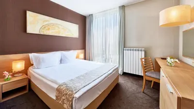 a hotel room with a bed and a desk at Lucky Bansko Aparthotel SPA & Relax in Bansko
