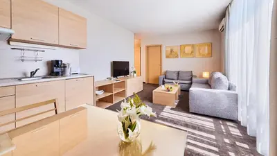 a kitchen and living room with a couch and a table at Lucky Bansko Aparthotel SPA & Relax in Bansko