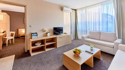 a living room with a couch and a tv at Lucky Bansko Aparthotel SPA & Relax in Bansko