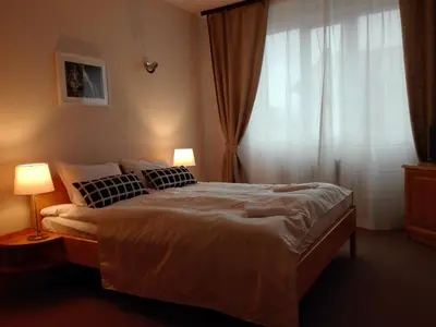 a bedroom with a bed with two lamps and a window at Horizont Dobrinishte in Dobrinishte