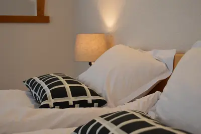 a room with two beds with pillows and a lamp at Horizont Dobrinishte in Dobrinishte