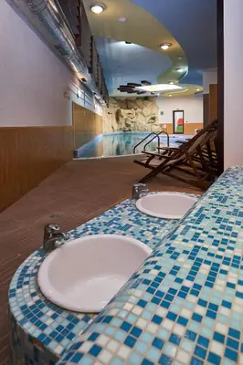 a bathroom with three sinks and a swimming pool at Sunrise Park Hotel Bansko - Free Wellness in Bansko