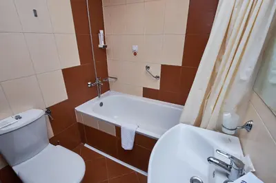 a bathroom with a toilet and a sink and a tub at Sunrise Park Hotel Bansko - Free Wellness in Bansko