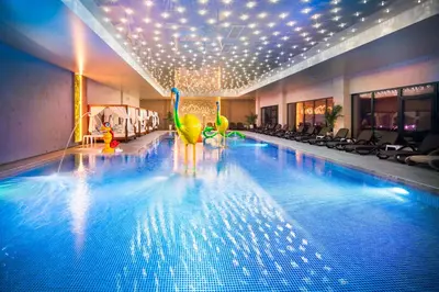 a large swimming pool with a gym with chairs and a pool at Park & Spa Hotel Markovo in Plovdiv
