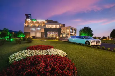 a car parked in front of a hotel with flowers at Park & Spa Hotel Markovo in Plovdiv