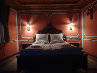a bedroom with a large bed with orange walls at Once upon a time in Koprivshtitsa