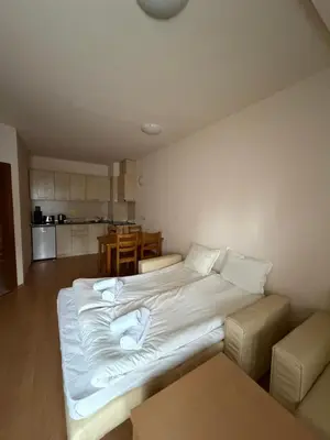a large white bed in a room with a kitchen at PM Services Royal Plaza Apartments in Borovets