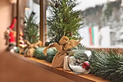 a shelf with miniature christmas trees and a glass bowl at Hotel Yastrebets Wellness & Spa in Borovets