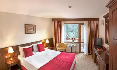 a hotel room with a large bed and a window at Hotel Yastrebets Wellness & Spa in Borovets