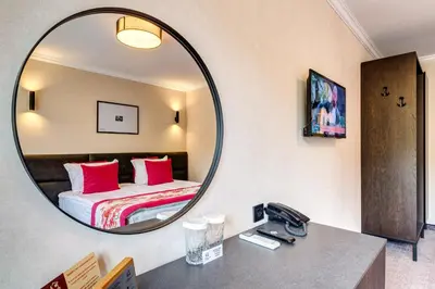 a mirror in a hotel room with a bed at SPA Hotel Kiparis in Smolyan