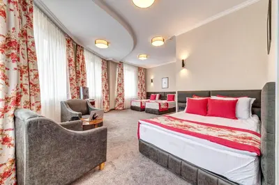 a hotel room with a bed and a chair at SPA Hotel Kiparis in Smolyan