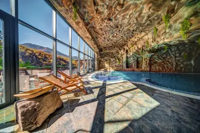 a pool in a building with a rock wall at SPA Hotel Kiparis in Smolyan