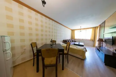 a living room with a dining room table and a couch at Forest Nook Aparthotel in Pamporovo