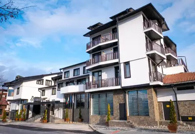 an apartment building with balconies on a street at Riverside Boutique Hotel in Bansko