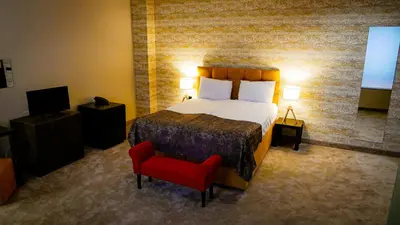 a bedroom with a bed and a red chair at Riverside Boutique Hotel in Bansko