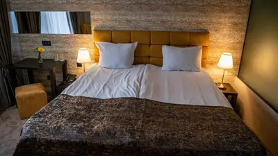 a bedroom with a large bed with two lamps at Riverside Boutique Hotel in Bansko