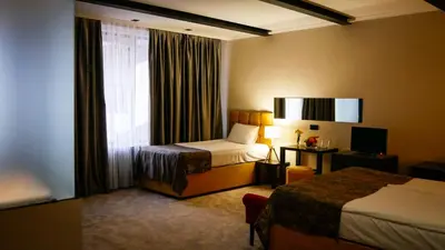 a hotel room with two beds and a window at Riverside Boutique Hotel in Bansko