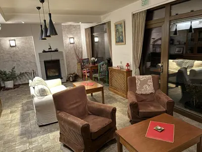 a living room filled with furniture and a bedroom at Hotel Smilen in Smolyan