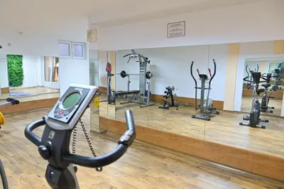 a gym with several exercise bikes and a mirror at Hotel Bojur & Bojurland Apartment Complex in Bansko