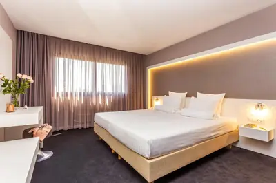 a hotel room with a large bed and a window at Grand Hotel Plovdiv in Plovdiv