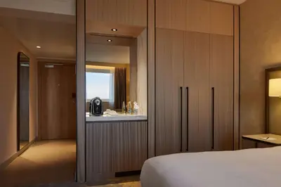 a bedroom with a bed and a large wooden cabinet at Hilton Sofia in Sofia