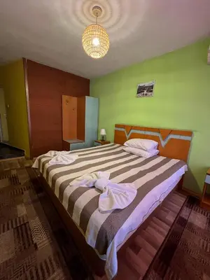 a bedroom with a large bed with towels on it at ALPHA family HOTEL in Blagoevgrad