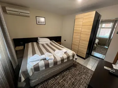 a bedroom with a bed with towels on it at ALPHA family HOTEL in Blagoevgrad