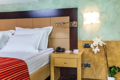 a hotel room with a bed and a phone on a night stand at Eurostars Sofia City in Sofia