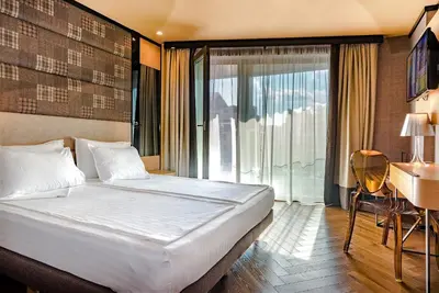 a bedroom with a bed and a desk and a window at Eurostars Sofia City in Sofia