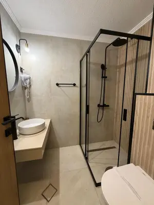a bathroom with a shower and a toilet and a sink at Elegant Lux Hotel in Bansko