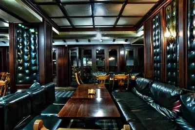 a restaurant with leather couches and a table and chairs at Hotel Friends in Bansko