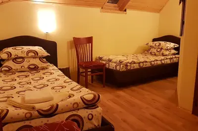a small room with two beds and a chair at Duvaro Guesthouse in Raduil
