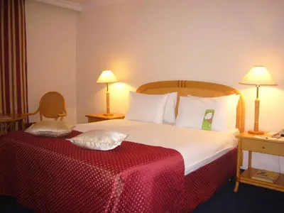 a hotel room with a large bed with a red blanket at Ramada by Wyndham Sofia City Center in Sofia