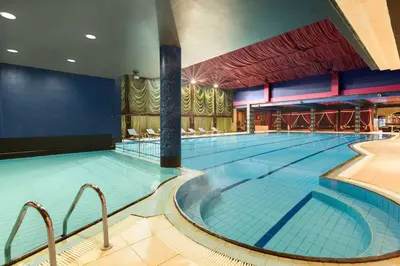 a large indoor swimming pool with a large swimming pool at Ramada by Wyndham Sofia City Center in Sofia