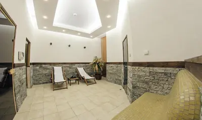 a room with two chairs and a stone wall at Green Life Family Apartments Pamporovo in Pamporovo