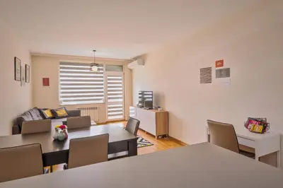 a living room with tables and chairs and a couch at Vitosha View One Bedroom Apartment by Flat Mаnager in Sofia