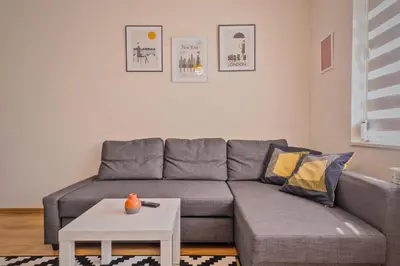 a living room with a gray couch and a white table at Vitosha View One Bedroom Apartment by Flat Mаnager in Sofia