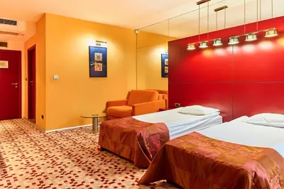 a hotel room with two beds and a chair at Monet Hotel in Plovdiv